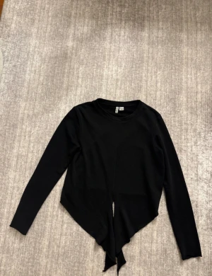Stickad tröja  - Säljer en svart stickad tröja i storlek M från H&M. Tröjan kan knytas framifrån. 