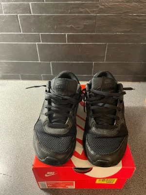 Nike Air Max 90 svart sneakers 39 - Svarta Nike Air Max 90 sneakers med mesh och skinnpaneler, klassisk rund tå och platt sula. Snygg low-top modell med snörning och diskret Nike Air-logga på hälen. Perfekt för dig som gillar stilrena och sportiga skor. Pris kan även diskuteras