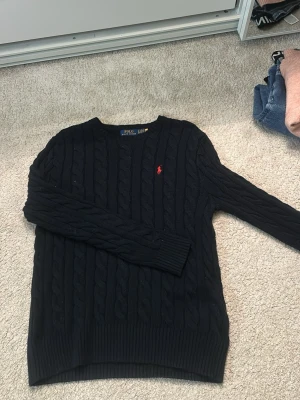 Mörkblå tröja Polo Ralph Lauren - Säljer en knappt använd tröja från Ralph Lauren, endast använd 1 gång men köpt för ca ett halvår sen.  Strl s men skulle säga mer som en m 