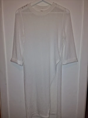 Vit asymetrisk klänning - Vit klänningen/topp i en enkel och stilren design.