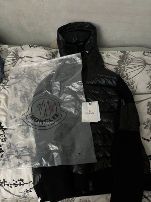 Svart Moncler pufferjacka med huva -  Väldigt fin Moncler Cardigan. Stilren, lätt och perfekt lagerplagg med premiumkänsla. Oanvänd och i fint skick. ✅ Oanvänd ✅ Fraktas 1 till 2 dagar alltid diskuteras vid snabb affär 💯
