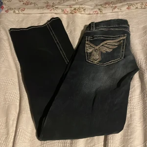 Bootcut jeans med broderade fickor Gina Tricot - Snygga mörkblå bootcut jeans från Gina Tricot med kontrastsydda sömmar och broderade bakfickor med coolt mönster. Jeansen har normal passform och är tillverkade i klassiskt denimtyg. Perfekt för dig som gillar detaljer och unik stil.Nyskick!!