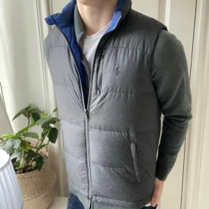 Ralph Lauren dun väst Reversible  - Ralph Lauren dun väst Reversible i färgen blå / grå. Storleken Xl barn vilket motsvarar S i herr ungefär. Extremt fin väst som är perfekt nu i vinter. Storleks lappen står i fickan. Kom med frågor 👌
