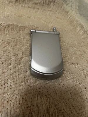 Två sminkspeglar i unik design - Säljer två sminkspeglar – en i silverfärgad plast som ser ut som en retro flip phone och en rund brun spegel med kex/chokladkaka-design. Perfekta att ha i väskan för snabba touch-ups. Båda är kompakta och lätta att ta med sig.  39kr/st 