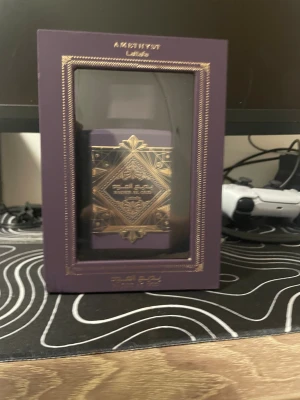 Lattafa Badee Al Oud Amethyst - Snygg parfym med lyxig lila och guld design från Lattafa. Flaskan har namnet Badee Al Oud Amethyst. Perfekt för dig som vill sticka ut med en unik och trendig flaska. Köpte den till lillebrorsan och han ville inte ha den så tänkte att säljaren skriv till mig om du är intresserad att köpa😀