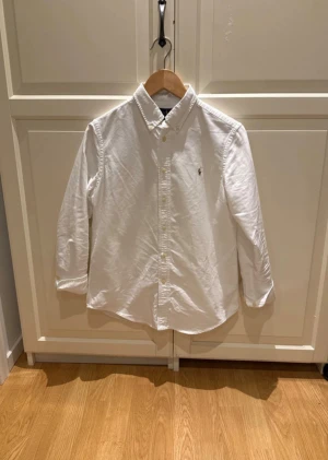 Vit Ralph Lauren Skjorta - Polo Ralph Lauren Skjorta - Skick: 9/10 - Storlek: 16 passar dig som är 160-170cm - Modellen är 170cm - Pris: 399kr. Kom DM vid fler bilder eller funderingar🥰