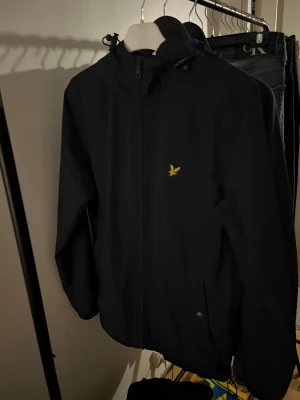 Svart vindjacka från Lyle & Scott - Svart vindjacka från Lyle & Scott perfekt för blåsiga dagar och enkel att matcha med det mesta.