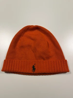 Ralph Lauren Mössa - Ralph Lauren mössa i väldigt bra skick. Orange med grön logga och one size. 