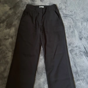 Svarta kostymbyxor från Madlady - Svarta kostymbyxor från Madlady i klassisk rak modell medel midja och bälteshällor. Byxorna har diskreta fickor i sidorna och är tillverkade i ett mjukt tyg som ger en clean och stilren look. Perfekta för dig som gillar minimalistisk stil. Använda fåtal gånger, skriv vid fler funderingar 💕