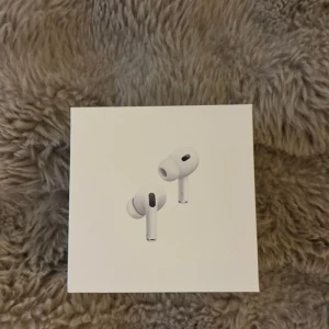 AirPods Pro - Säljer ett par Apple AirPods Pro i originalförpackning. Komplett med laddningsetui och laddningskabel. Hörlurarna och tillbehören ser ut att vara i mycket gott skick, utan synliga repor eller skador. Perfekt för trådlös musik och samtal med aktiv brusreducering.