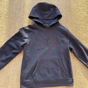 Mörkblå hoodie från Polo Ralph Lauren - Snygg mörkblå hoodie från Polo Ralph Lauren med broderad logga framtill. Klassisk modell med huva, magficka och långa ärmar. Köpte den nyligen för 1700kr men den va för liten. Perfekt nu när det närmar sig kallare tider🥶