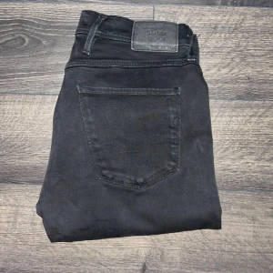 Replay Anbass jeans - Säljer ett par svarta Replay Anbass jeans i slim fit med klassisk femficksdesign. Jeansen har snyggt smal passform, normal midja och är tillverkade i mjukt bomullsmaterial med stretch. Perfekta för dig som gillar stilrena och bekväma jeans. Midja 40cm, längd 105cm. JAG SKICKAR INGA FLER BILDER PÅ NÄR JAG BÄR PLAGGET:) s2