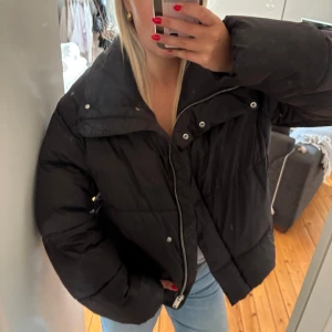 Svart pufferjacka med hög krage - Säljer en svart pufferjacka med riktigt hög och mysig krage. Super varm nu till kallare dagar. Är storlek XS, men passar mig som vanligtvis har S. 🌸