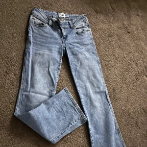 Ljusblå jeans med broderade bakfickor - Säljer ett par ljusblå jeans från 157 i storlek S. Jeansen har raka ben och snygga broderade detaljer på bakfickorna. Klassisk femficksmodell med gylf och knapp. Perfekta för dig som gillar en enkel men ändå unik look.