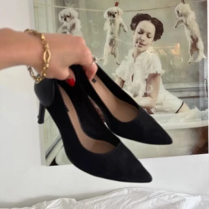Svarta klackar med spetsig tå - Snygga svarta pumps från H&M med spetsig tå och hög klack. Skorna är gjorda i mocka och skinn, vilket ger en stilren och klassisk look. Perfekta för dig som gillar minimalistisk stil och vill ha ett par eleganta klackar i garderoben.