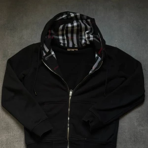 Svart Burberry hoodie med dragkedja - Svart Burberry hoodie perfekt nu för hösten!🍁Mycket bra Skick✅skickar samma dag!📩 Kan gå ner i pris vid snabb affär🧑‍💼skickar med en nocco 🍾Och hör av er om frågor!