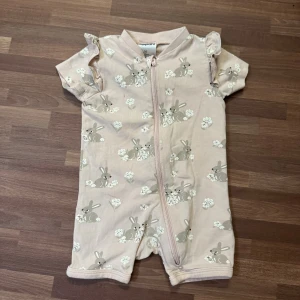 Ljusrosa pyjamas med kaniner - Mysig ljusrosa pyjamas från Kappahl i storlek 56 (1-2mån). Hel dragkedja framtill. Sparsamt använt. 