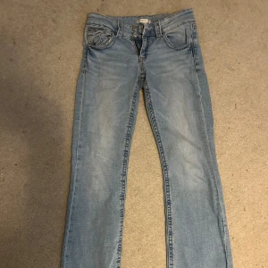 Ljusblå lågmidjade bootcut jeans - Säljer ett par ljusblå bootcut från Gina Tricot i storlek 164. Dom är lite stretchiga och lågmidjade