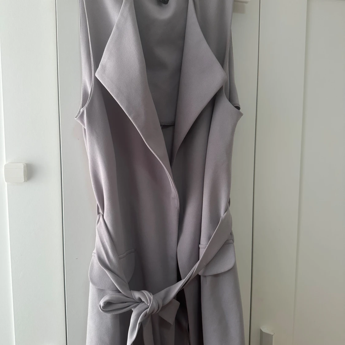 Ljusgrå lång väst med knytband
