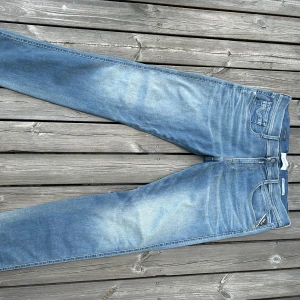 🔥Replay Anbass slim🔥 - Säljer ett par snygga Replay jeans i ljusblå tvätt med slitningar och klassiska femficksdetaljer. Jeansen har raka ben och normal passform, perfekt för dig som gillar en avslappnad stil. Materialet är mjukt jeans och modellen är tidlös. Andvända 1 gång. Har fler bilder och mått! Passar  180 - 190 cm📏