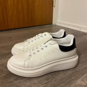 Vita chunky sneakers med svart detalj - Snygga vita sneakers med chunky plattformssula och svart detalj på hälen. Skorna är helt nya, endast provade! 