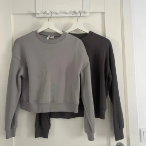 2 basic sweatshirts från H&M Divided XS - Två stilrena sweatshirts från H&M Divided i storlek XS. En i ljusgrått och en i mörkgrått, båda med rund hals och långa ärmar.