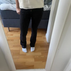 Svarta bootcut jeans från Levi's - Säljer ett par svarta Levi's jeans med bootcut-modell. Byxorna har klassiska bakfickor och Levi's-lapp bak i midjan. De är tillverkade i ett mjukt bomullsmaterial med lite stretch och design på bakfickorna. W24