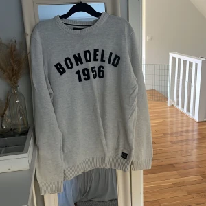 Ljusgrå sweatshirt från Bondelid - Ljusgrå sweatshirt från Bondelid med svart tryck 'Bondelid 1956' på bröstet. Min brorsas gamla tröja och inte använd på ett tag. Bra skick!