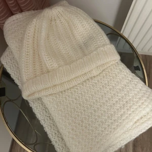 Vit stickad mössa och halsduk från Gina Tricot - Mysig vit stickad mössa och halsduk som är ribbstickade från Gina Tricot. 