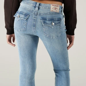 Bootcut jeans true religion  - Säljer ett par ljusblå bootcut  jeans från True Religion med ikoniska bakfickor och silverfärgade knappar. Jeansen har normal midja och klassisk femficksdesign. Perfekta för dig som gillar snygga detaljer.priset är ej fast!💞