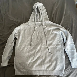 Grå stickad hoodie - En grå stickad hoodie perfekt nu till vintern. Skick 10/10 är aldrig använda. Vårt pris 549kr. Hör av er vid funderingar.