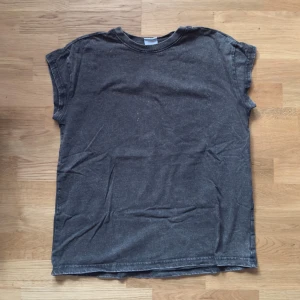 Mörkgrå basic t-shirt Gymshark - En enkel mörkgrå t-shirt med rund hals och korta ärmar. T-shirten har en avslappnad passform och är tillverkad i mjuk bomull. 