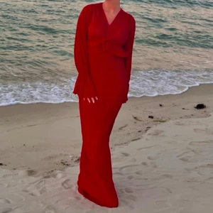 Röd långklänning med v-ringning - Röd långklänning med v-ringad hals och långa ärmar. Volang under byst är borttaget. Se bild 2 och 3. 