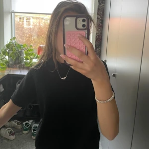 Svart fluffig t-shirt - Säljer en svart t-shirt med korta ärmar i ett mjukt och fluffigt material. Enkel och stilren design som passar perfekt till jeans eller kjol. T-shirten har rund hals och är riktigt skön att ha på sig.