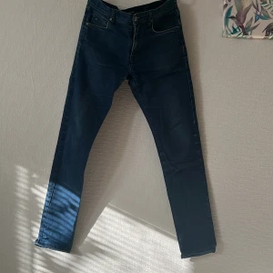 J.Lindeberg Damien jeans blå - Snygga blå jeans från J.Lindeberg, modell Damien. Klassisk femficksdesign med raka ben och diskreta slitningar. Jeansen har normal passform och är tillverkade i mjukt bomullstyg med en hint av stretch för extra komfort. W30 L32