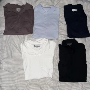 Fem klassiska skjortor i olika färger - 1. Brunlila stickad kortärmad skjorta från hm i storlek S 2. Ljusblå pike från dressmann i storlek S 3. Marinblåa stickad pike från selected homme i storlek S 4. Vit frotté pike från s&t studios i storlek xs (sitter som S) 5. Marinblå stickad långärmad piké från hm i storlek S (100% ull)