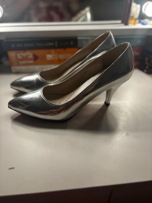 Silvriga pumps med röd sula - Jättefina klackskor med röd sula. De är i storlek 40 med en cirka 4cm klack❤️