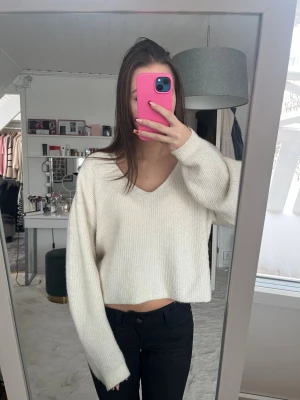 Vit v-ringad stickad tröja från H&M - Säljer en vit stickad tröja från H&M med v-ringning och croppad passform. Den är i storlek M men passar även storlek S. Jag har använt den fåtal gånger så den är fortfarande i bra skick💕💕
