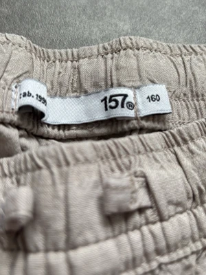 Beiga linnebyxor med resårmidja - Säljer ett par beiga linnebyxor från 157 med avslappnad passform och resår i midjan. Byxorna har sidfickor fram och en bakficka. Perfekta för chill dagar och riktigt sköna tack vare det tunna linnematerialet.