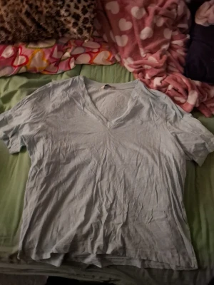 Ljusblå v-ringad t-shirt - En enkel ljusblå t-shirt med v-ringning och korta ärmar. Tillverkad i mjukt bomullsmaterial som känns skönt mot huden. Perfekt för en avslappnad och chill stil.