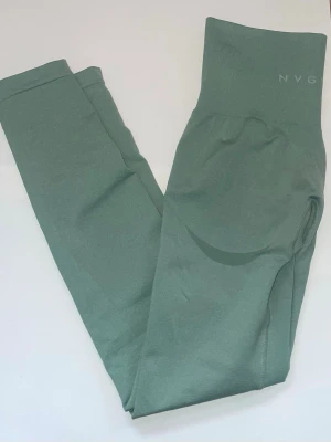 Gröna träningstights från NVGTN - Snygga gröna leggings från NVGTN med hög midja och tight passform. Perfekta för träning eller chill, med diskret logga upptill och stretchigt material som sitter skönt hela dagen.