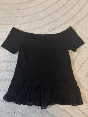 Svart topp  - Säljer en svart offshoulder topp med volang ner till. Storlek S, från Zara💕