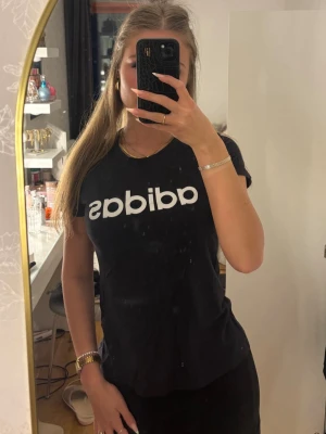 Svart Adidas t-shirt med vit logga - Svart t-shirt från Adidas med klassisk vit logga tryckt över bröstet. Modellen är kortärmad och har en normal passform. Vid frågor är det bara att skriva!💕💕