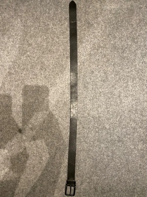 Svart skärp från Jack & Jones - Snyggt svart skärp från Jack & Jones i klassisk design med matt spänne. Skärpet är gjort i skinn och har präglad logga samt texten 'J&J est. 1990' på insidan. Perfekt för att lyfta vilken outfit som helst.