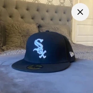 Svart Fitted Sox Keps New Era - Säljer min svarta sox keps (new era). Den är i jättegod skick och passar perfekt till den som vill ha streetstyle eller grisch stilen. Den är väldigt bekväm och har inga felaktigheter.