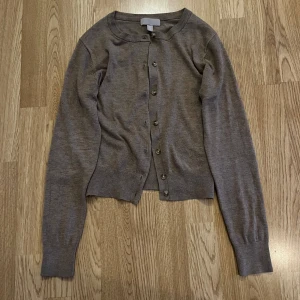 Brun kofta  - Jätte fin brun finstickad kofta från H&M i storlek XS. Koftan har rund halsringning, långa ärmar och knäppning framtill med matchande knappar.  