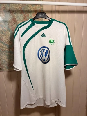 Wolfsburg 2009/10 Adidas shirt, size XL - Good condition.  #bundesliga #wolfsburg #volkswagen #adidas #germany #dzeko #grafite #barzagli  Vit fotbollströja med gröna detaljer från Adidas. Tröjan har Vfl Wolfsburg klubbmärke och Volkswagen logga på bröstet. Adidas loggan finns också på bröstet.