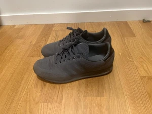 adidas LA Trainer Grey Sneakers Woven Trainers Retro Originals  - Säljer ett par mörkgrå Adidas sneakers, använda och döm har lite slitage. 