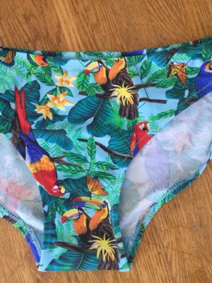 Färgglada bikiniunderdel med tropiskt mönster M - Färgglada bikinitrosor med ett mönster av tropiska växter, fåglar och fjärilar. Oanvända med tags!