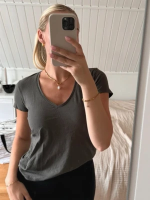 T-shirt från Zara - En basic mörkgrön t-shirt från Zara med v-ringning och korta ärmar. Skön och enkel modell